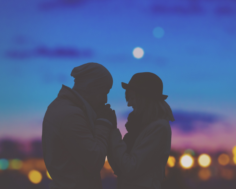 Silhouette of two people, sunset in the background